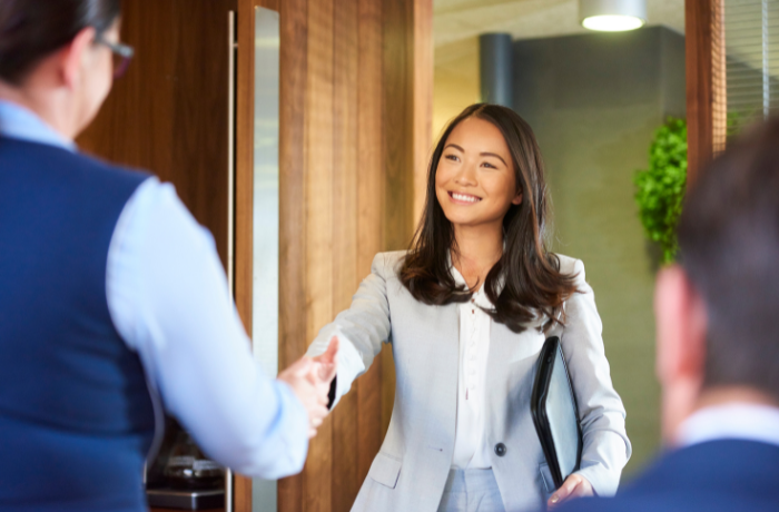 Woman shaking hands in career negotiation setting