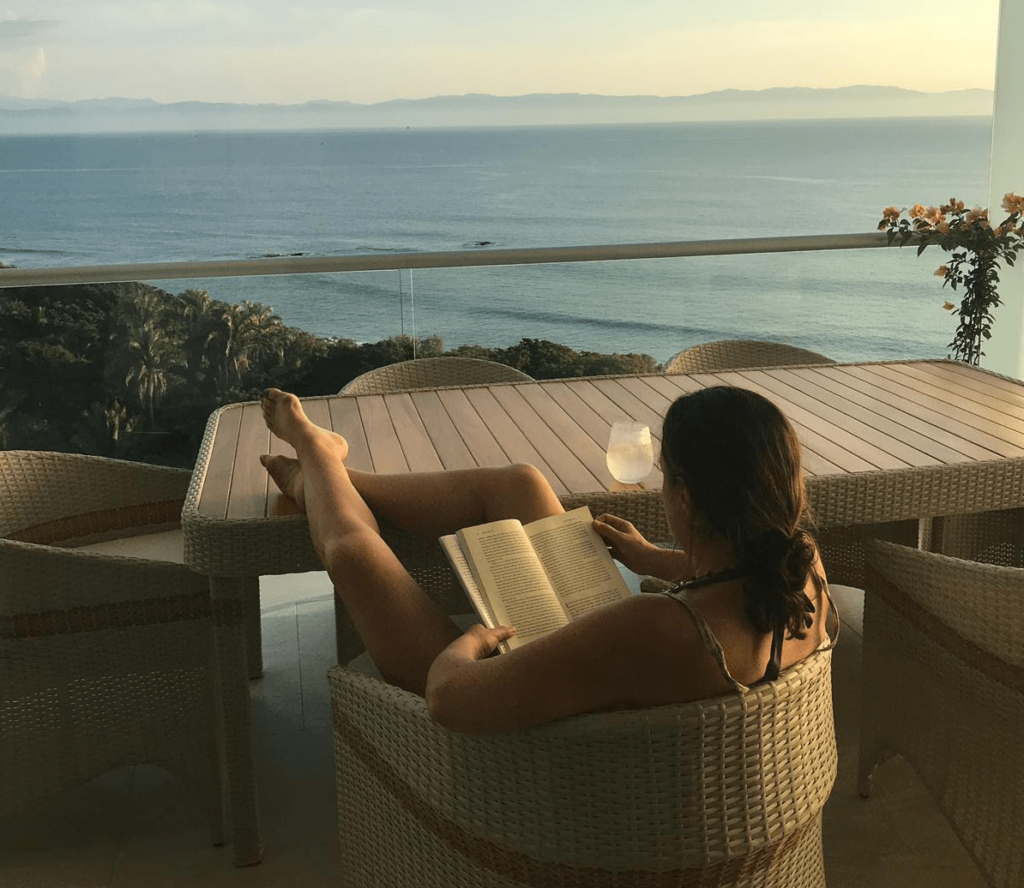 Woman reading peacefully by ocean