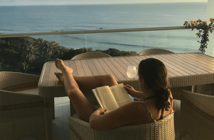 Woman reading peacefully by ocean