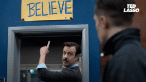 Ted Lasso pointing to his believe sign